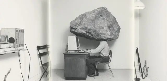 Burnout assessment service illustration representing a person sitting at a desk with a massive boulder balancing directly on their head