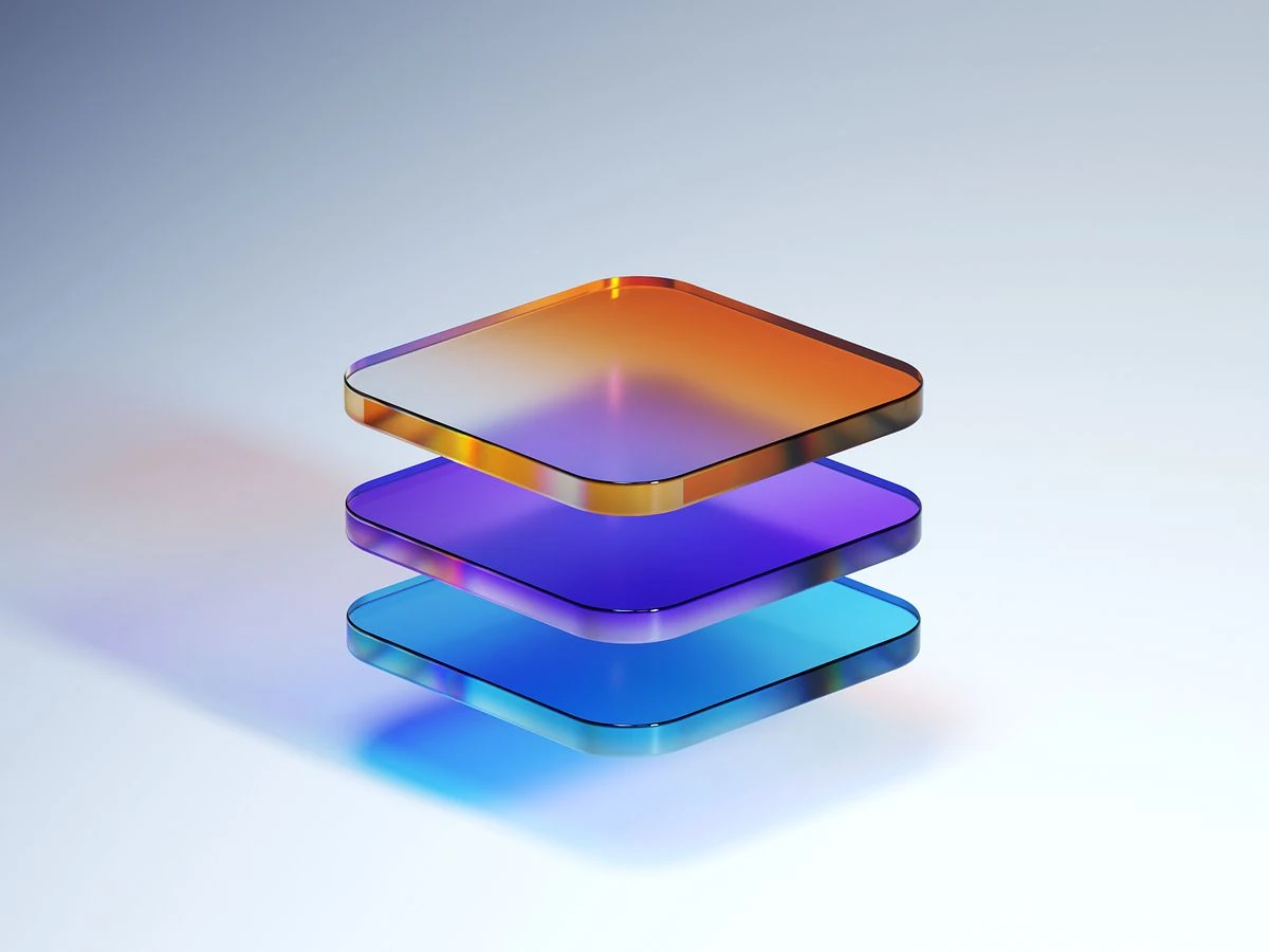 A stack of three colourful, semi-transparent rounded square plates floating on a light background